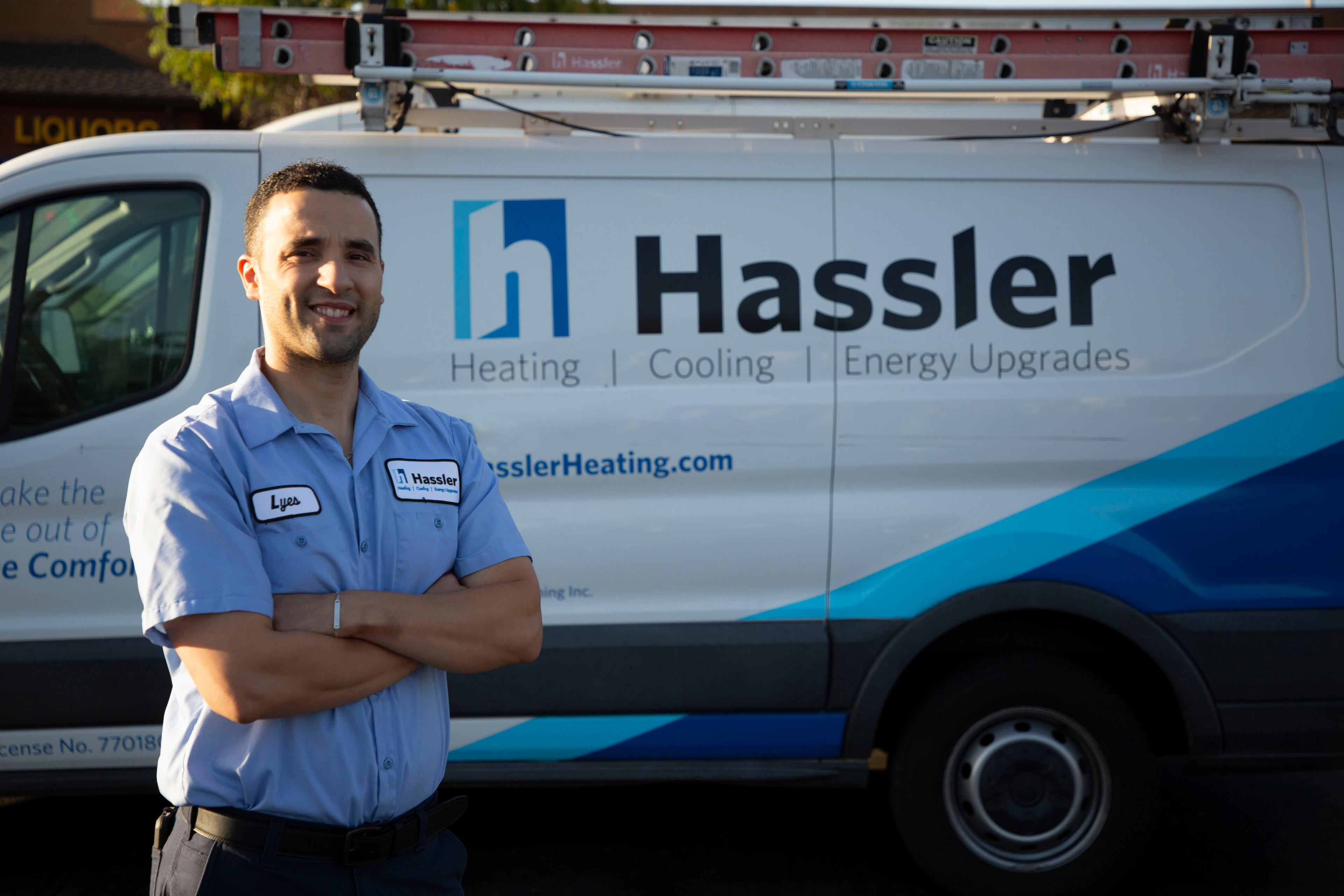 Picture of A Hassler technician poses next to one of the company's service trucks. - Hassler Heating & Air Conditioning, LLC