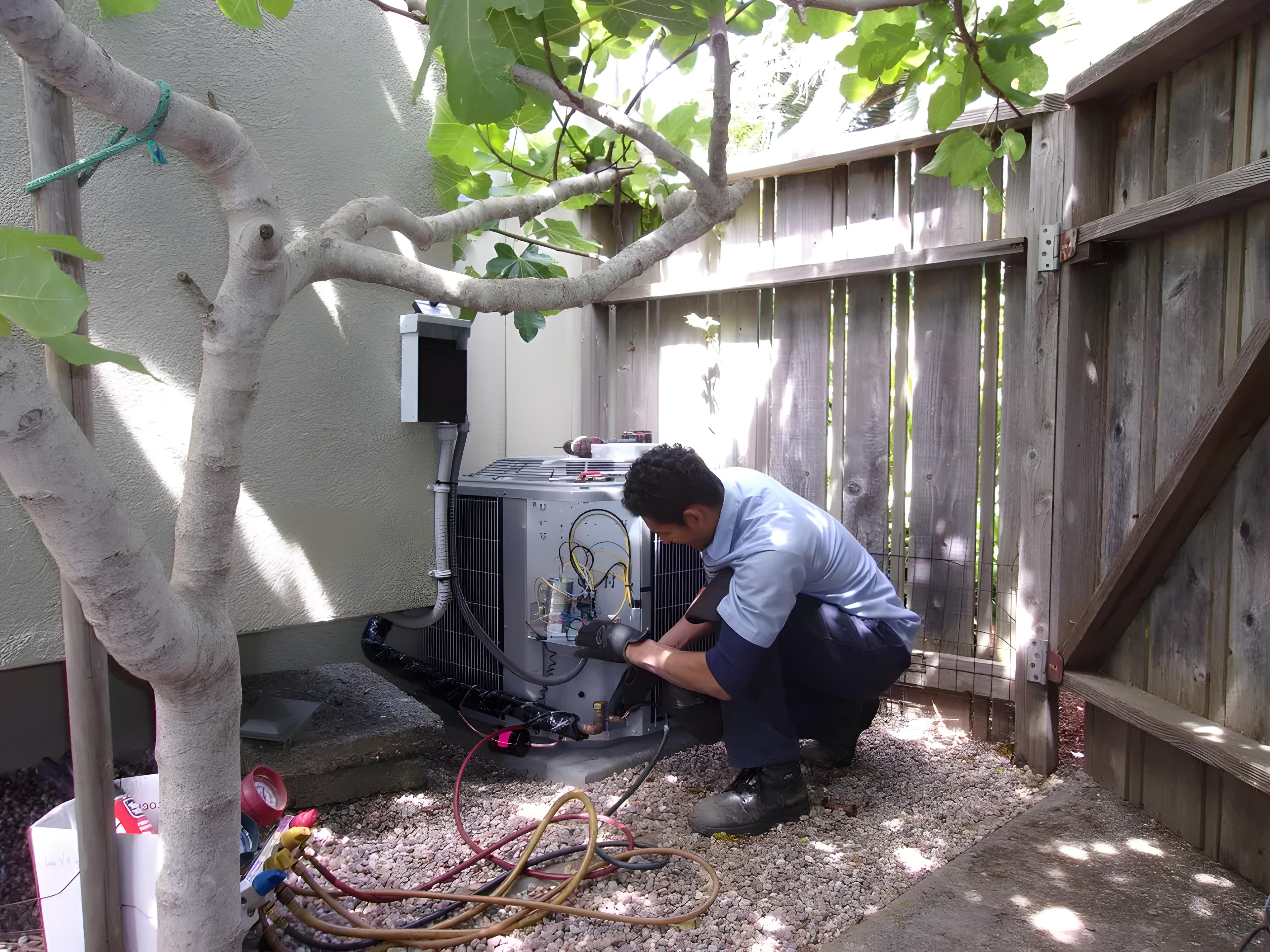 Picture of A Hassler technician services an outdoor HVAC unit. - Hassler Heating & Air Conditioning, LLC