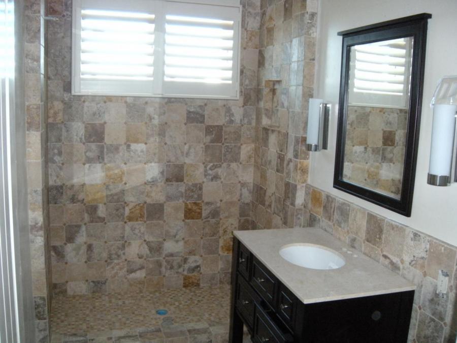 Picture of This guest shower features natural stone wainscot and mosaic floor tile. - DC Tile and Stone