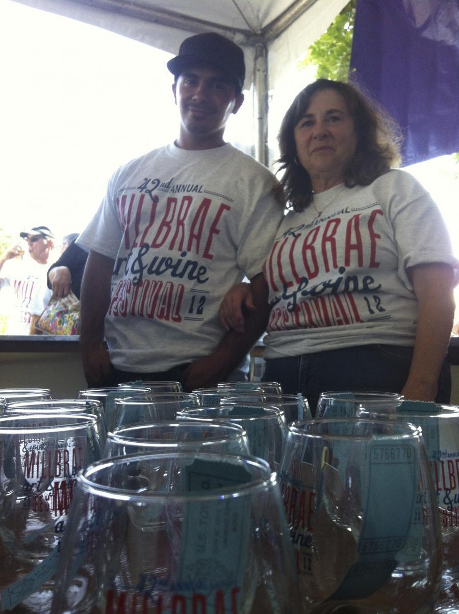 Picture of Co-owner Carol Frediani and technician Adrian volunteer at the Millbrae Art and Wine Festival. - AWC