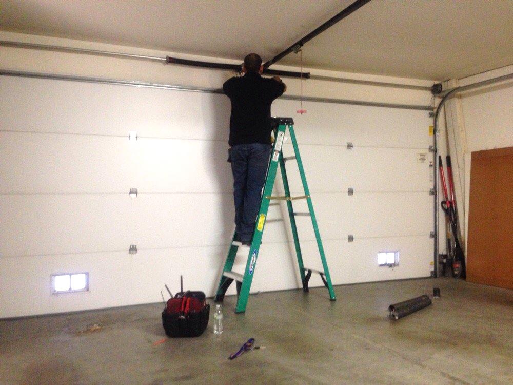 Picture of An Ace's Garage Door Repair & Installation technician works on a client's garage door. - Ace's Garage Door Repair & Installation
