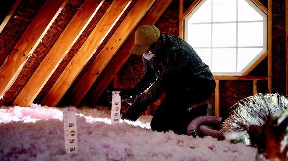 Picture of An Alcal Specialty Contracting technician installs new insulation in a customer's attic. - Alcal Specialty Contracting, Inc.
