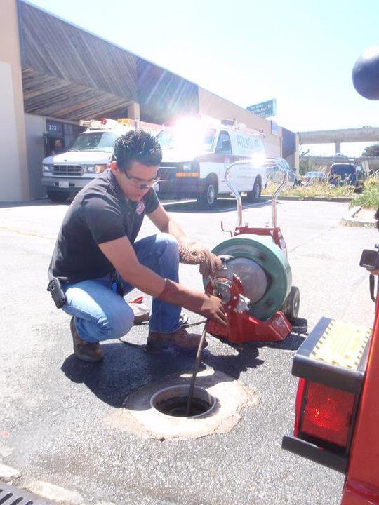 Picture of An Atlas Plumbing & Rooter technician works on a customer's sewer line. - Atlas Plumbing & Rooter