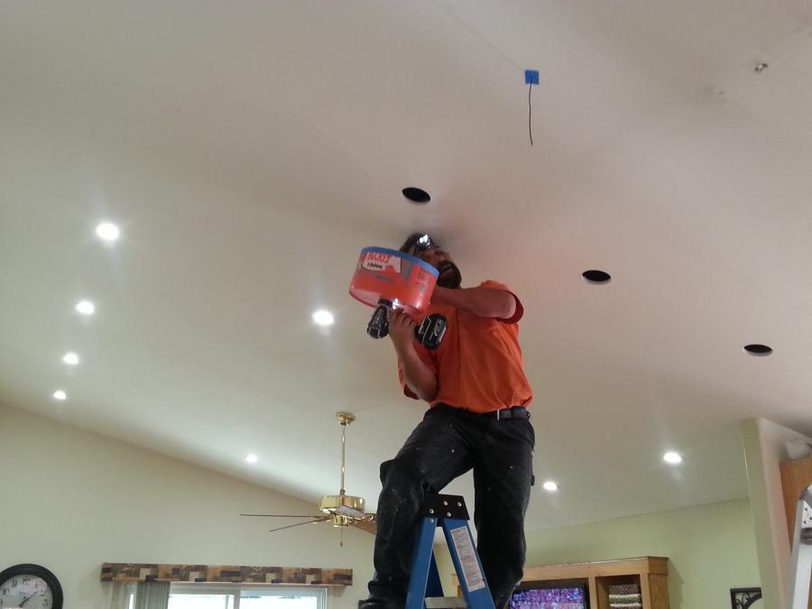 Picture of Owner Bill Henry installs an LED can light on a customer's ceiling. - B. Henry's Quality Electric Inc.