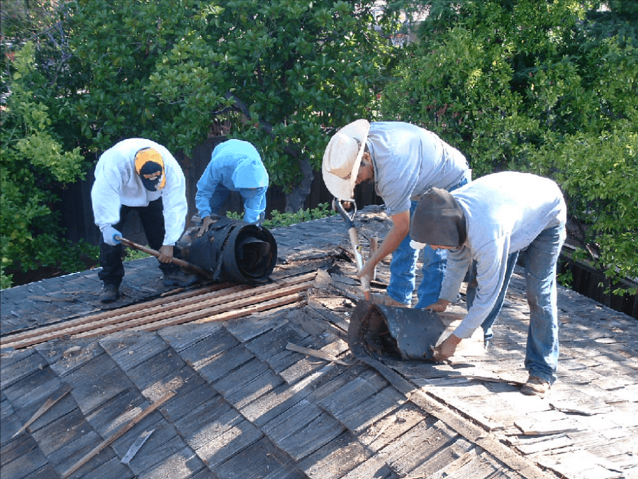 Picture of Bay 101 Roofing employees remove a customer's old roof. - Bay 101 Roofing, Inc.