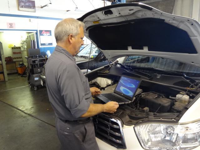 Picture of Bill Faulconer uses modern computer diagnostic equipment on a customer's car. - Renson Automotive