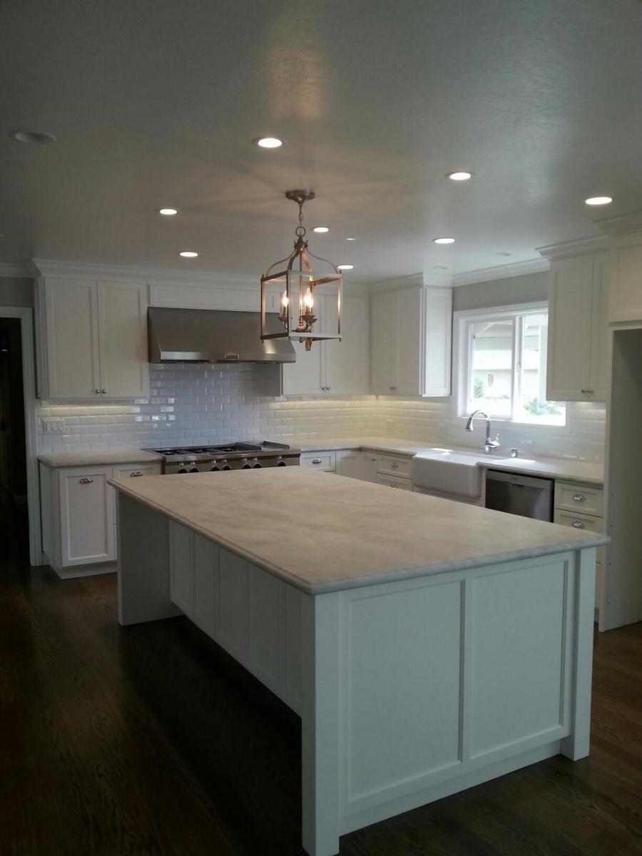 Picture of This kitchen remodel features white costume kitchen cabinets granite countertops an eight-foot kitchen island and new hardwood - Devengenzo Landscaping & General Engineering Inc.
