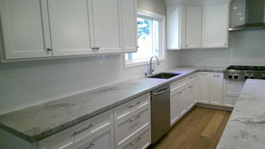 Picture of This kitchen remodel features white cabinets Quarzite countertops a stainless steel sink and new hardwood flooring. - Devengenzo Landscaping & General Engineering Inc.