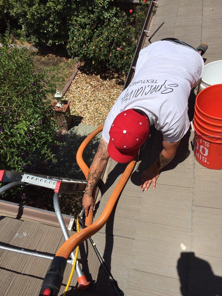 Picture of A Maintenance Agents technician cleans a client's gutters. - Maintenance Agents