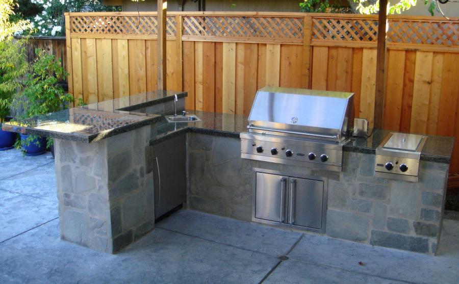 Picture of A large barbecue and stool bar made of concrete and covered with flagstone and granite tiles - Pacific Landscaping