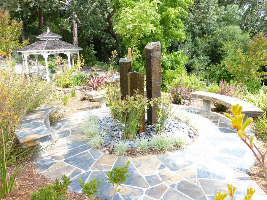 Picture of Pacific Landscaping installed this water fountain with three natural pillars and two flagstone-covered benches in Walnut Creek. - Pacific Landscaping
