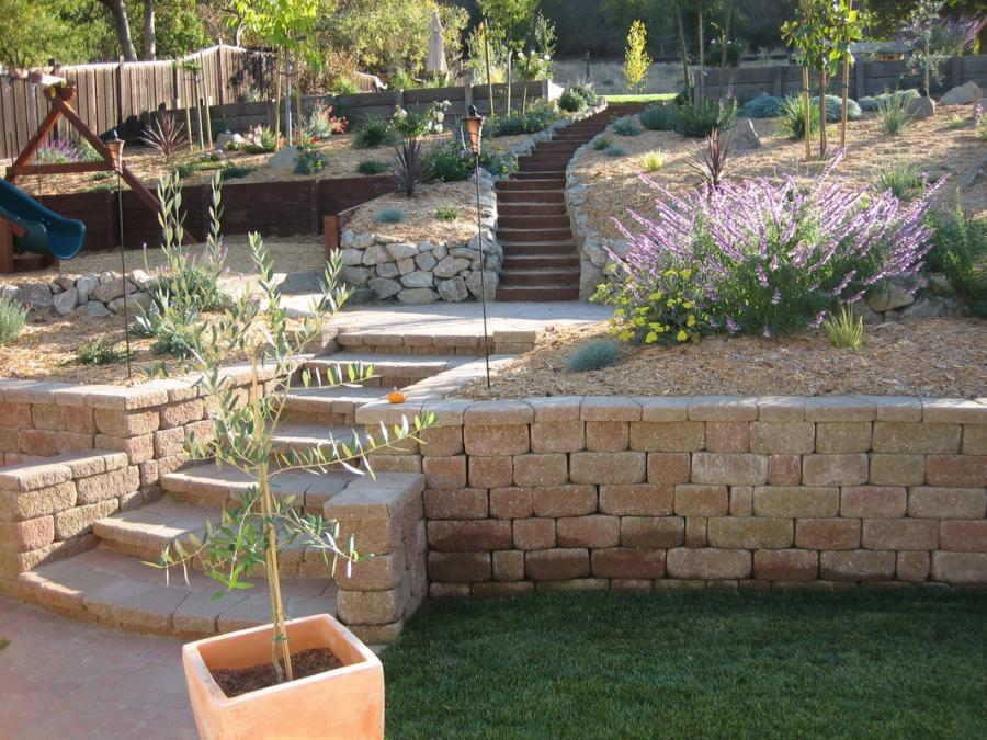Picture of This multi-level landscaping project features two retaining walls a play structure a patio and a small lawn. - Natural Landscaping Contractors