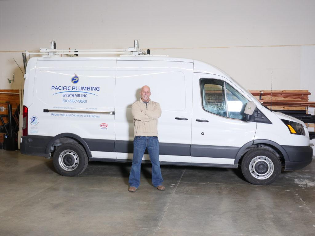 Picture of Owner Ron Beesley stands next to one of Pacific Plumbing Systems' service vans. - Pacific Plumbing Systems