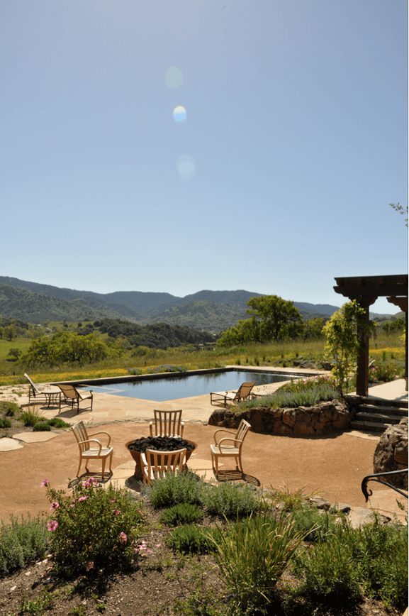 Picture of A meadow in bloom provides a colorful backdrop for this backyard swimming pool integrated spa and natural flagstone pool deck. - Jerry Allison Landscaping, Inc.