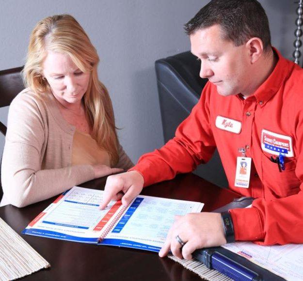 Picture of A Service Champions technician helps a customer with her paperwork. - Service Champions