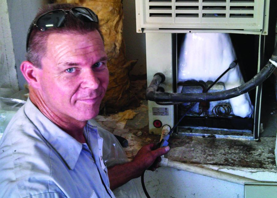 Picture of A Clean Air HVAC technician services a customer's system. - Clean Air HVAC, Inc.