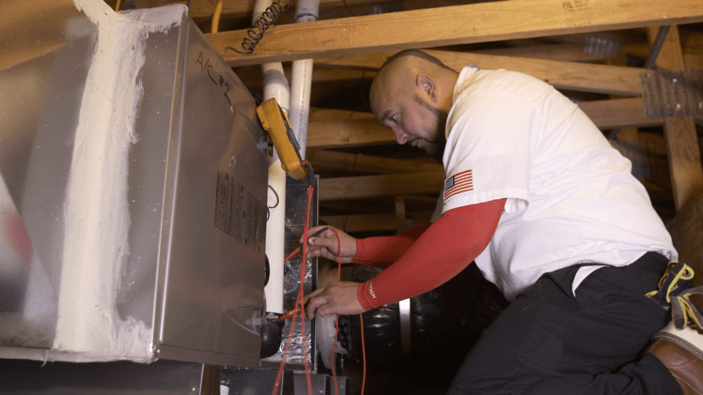 Picture of Senior Comfort Adviser Danny Mendoza services a client's furnace in Brentwood. - Perfect Star Heating and Air Conditioning