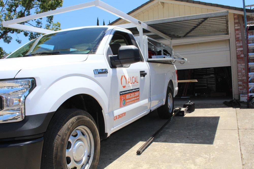 Picture of One of Alcal Specialty Contracting's garage door service trucks outside of a residential home - Alcal Specialty Contracting, Inc.