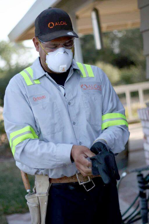 Picture of An Alcal Specialty Contracting employee puts on his personal protective equipment (PPE). - Alcal Specialty Contracting, Inc.