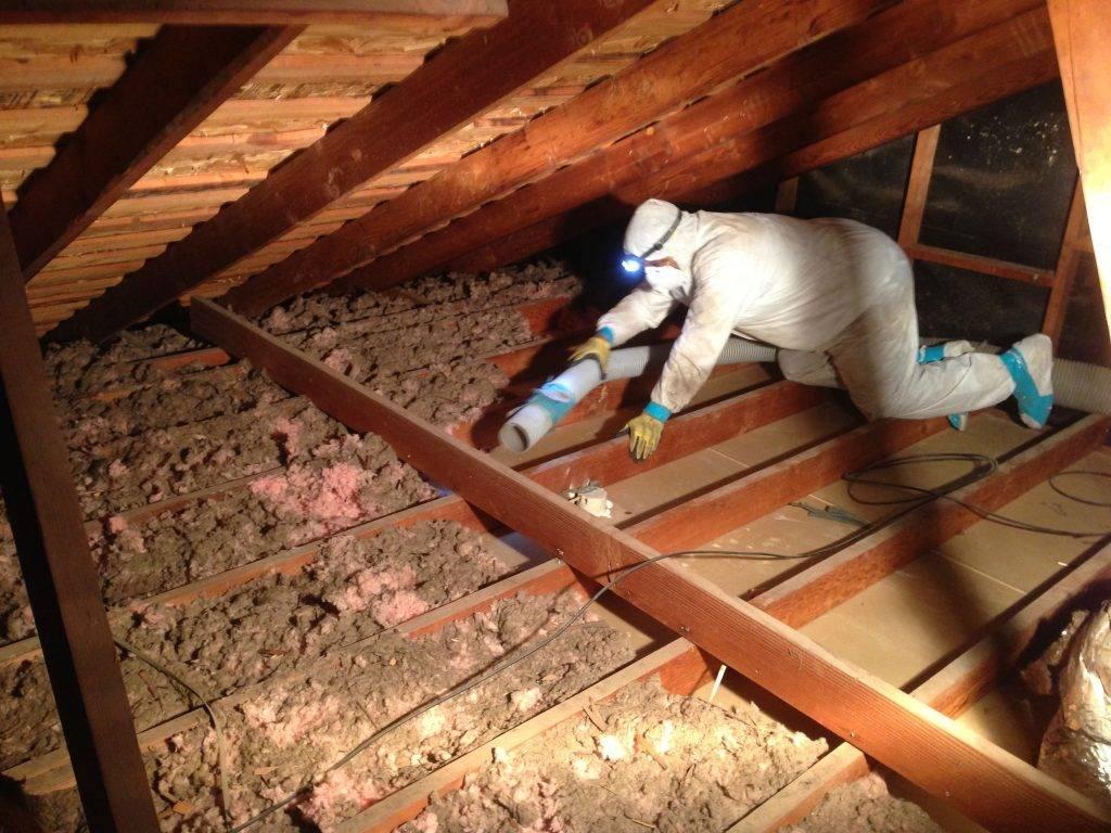 Picture of An Atticare technician cleans a customer's attic. - Atticare Construction
