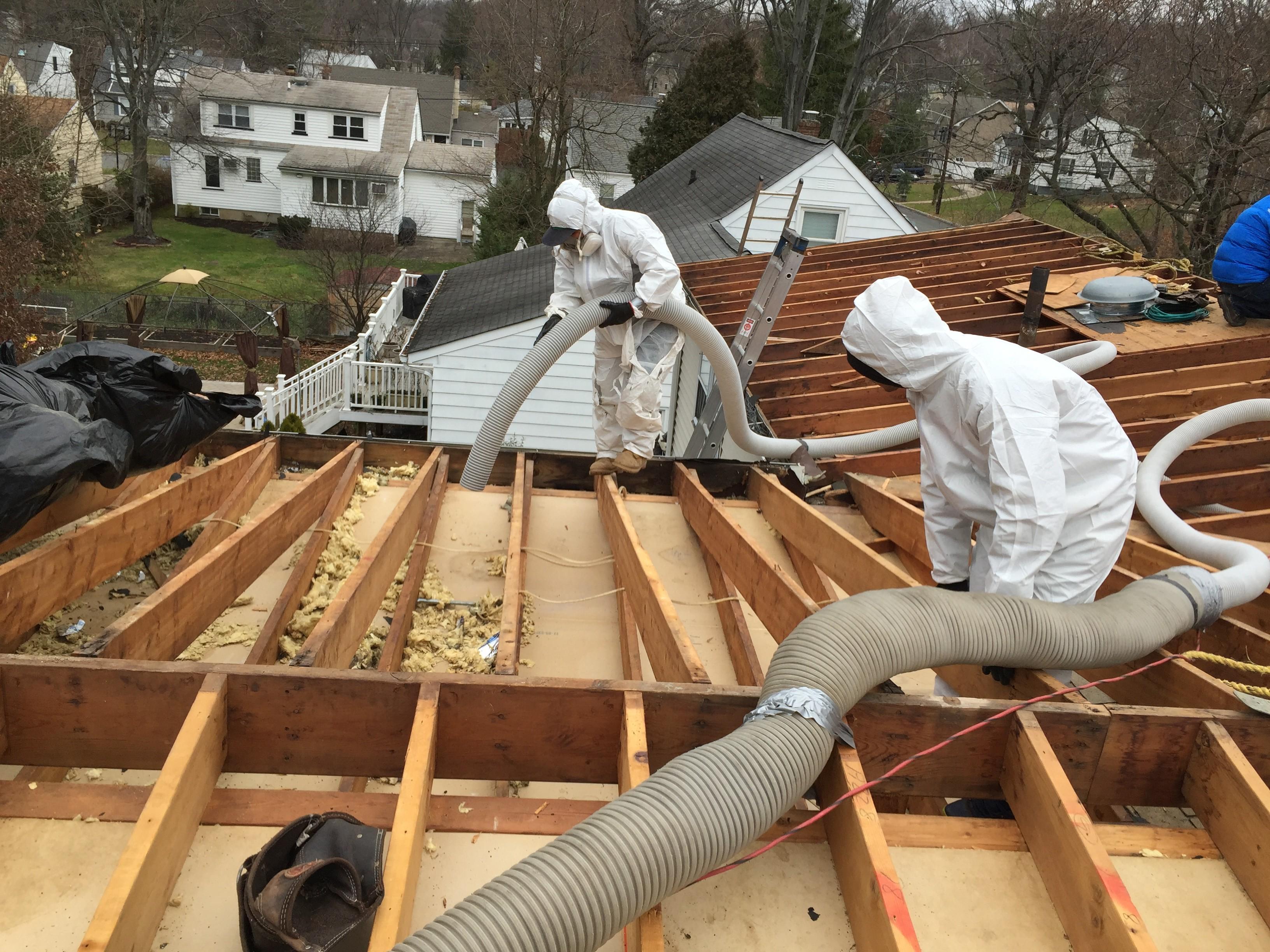 Picture of Two Atticare technicians work on a client's roof. - Atticare Construction