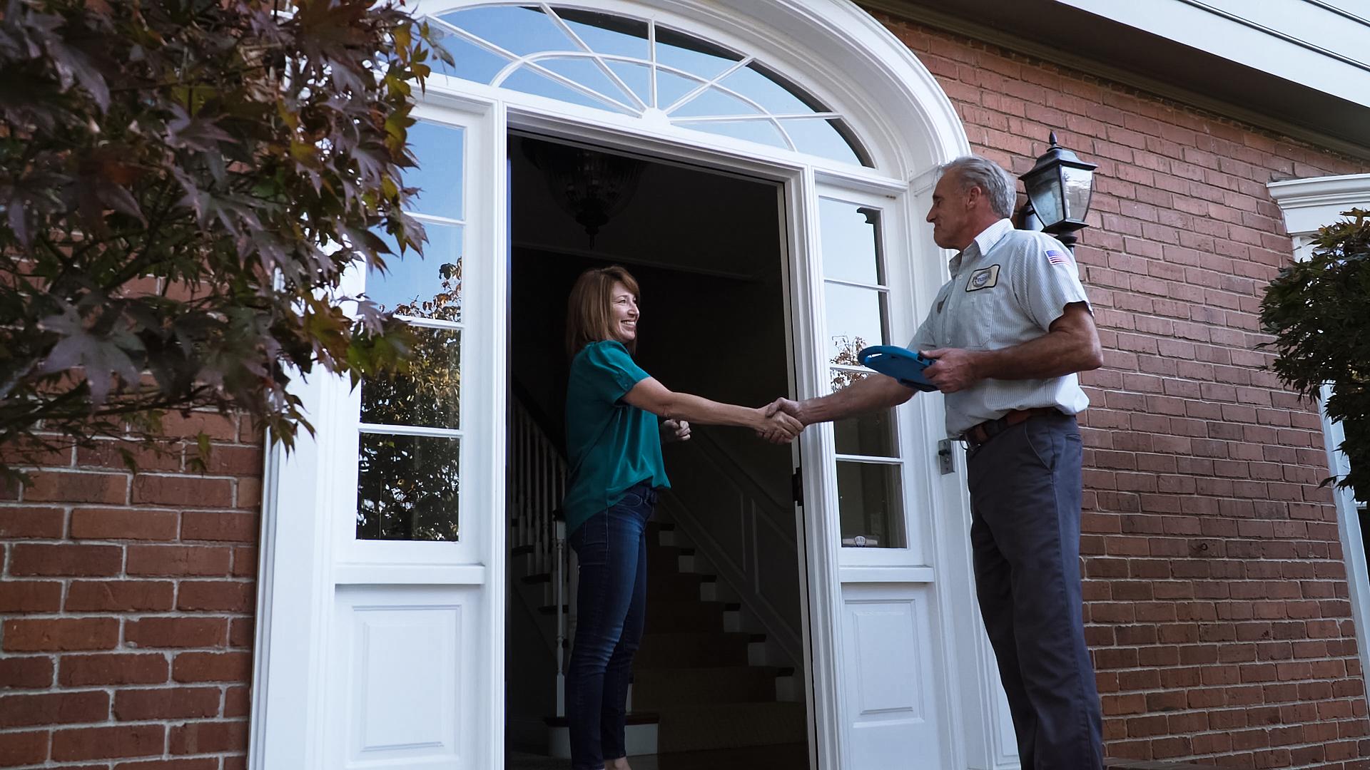 Picture of A Precision Door Services of the Bay Area technician greets a customer at her home. - Precision Door Services of the Bay Area