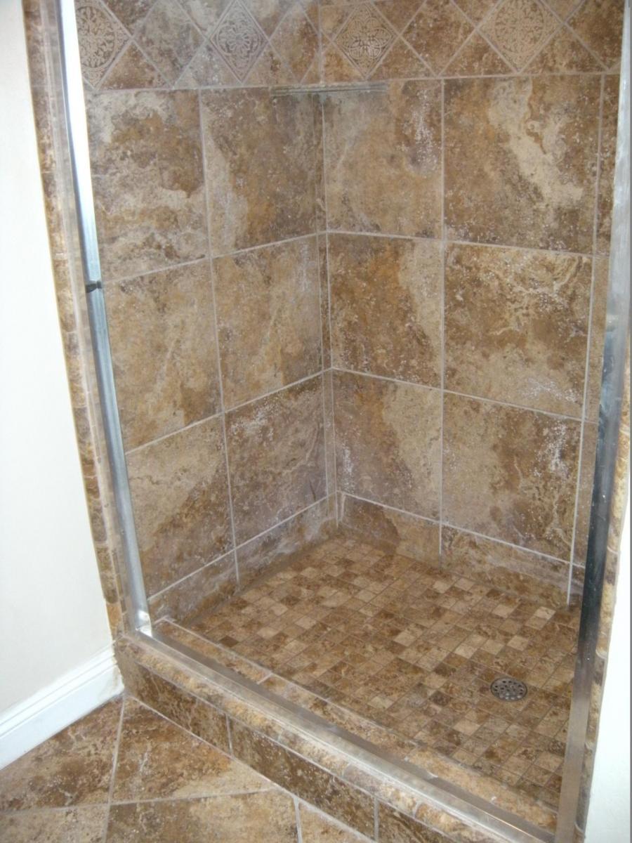 Picture of DC Tile and Stone installed the 2x2 floor tile and tumbled marble in this guest shower. - DC Tile and Stone