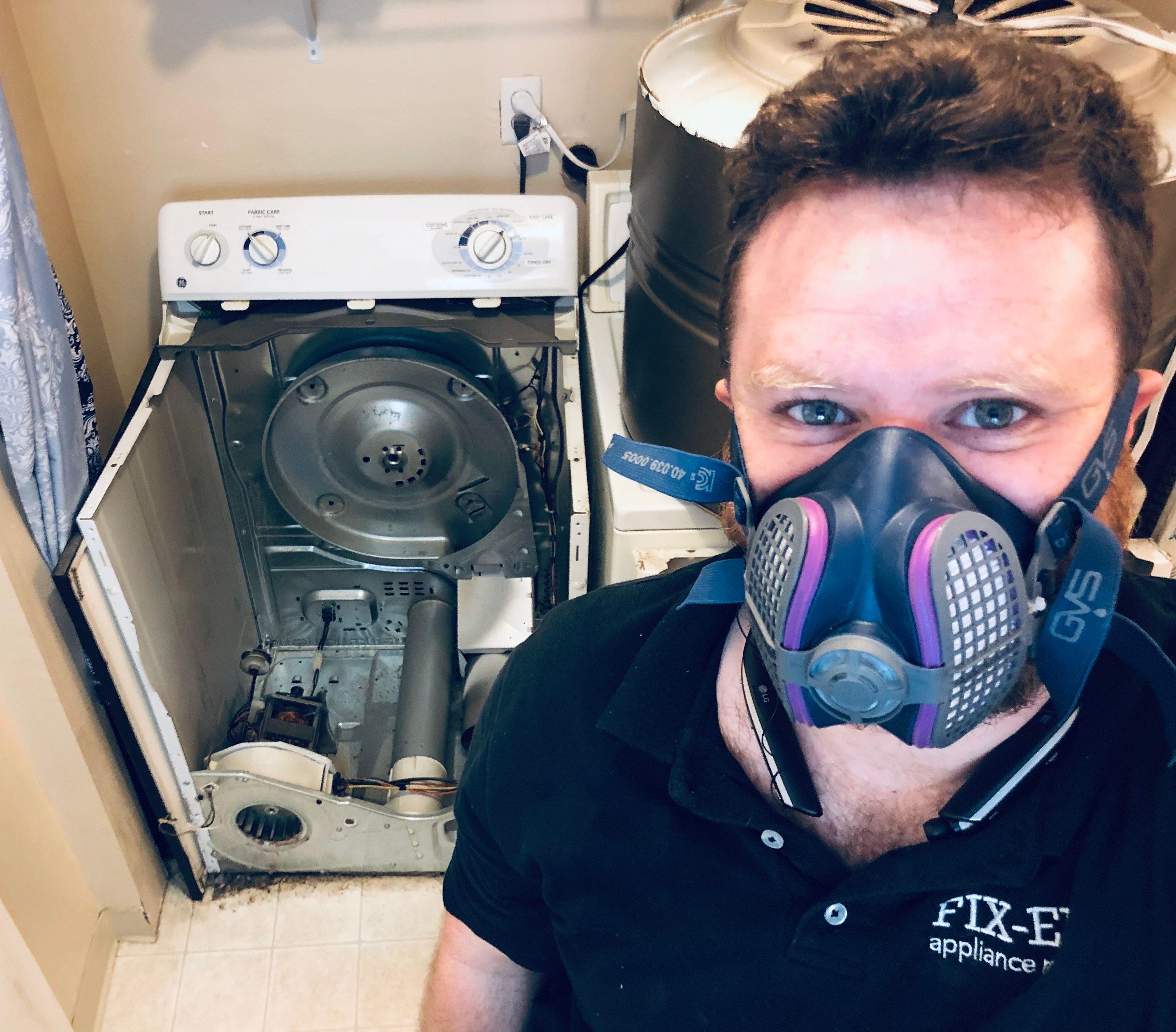 Picture of Co-owner Natan Framowitz does some preventative maintenance on a dirty lint-filled dryer. - FixEm Appliance Repair