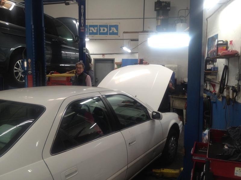 Picture of Service Advisor Stuart checks with an Acur-it Auto Repair technician to make sure the repair is going well. - Acur-it Auto Repair