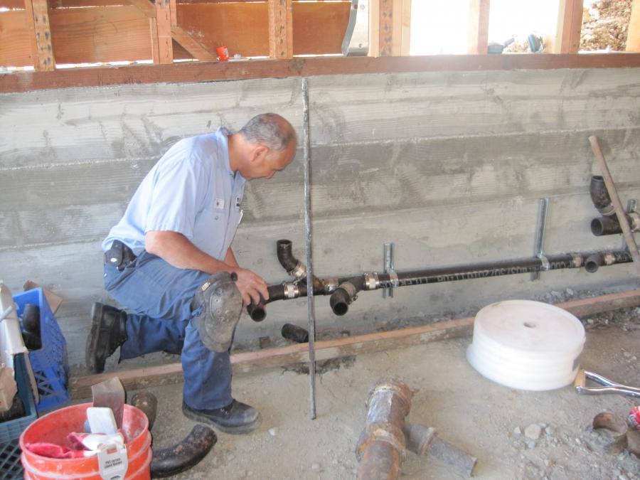 Picture of Albert Nahman Plumbing technician Rafael plumbs a rear outlet toilet. - Albert Nahman Plumbing, Heating and Cooling