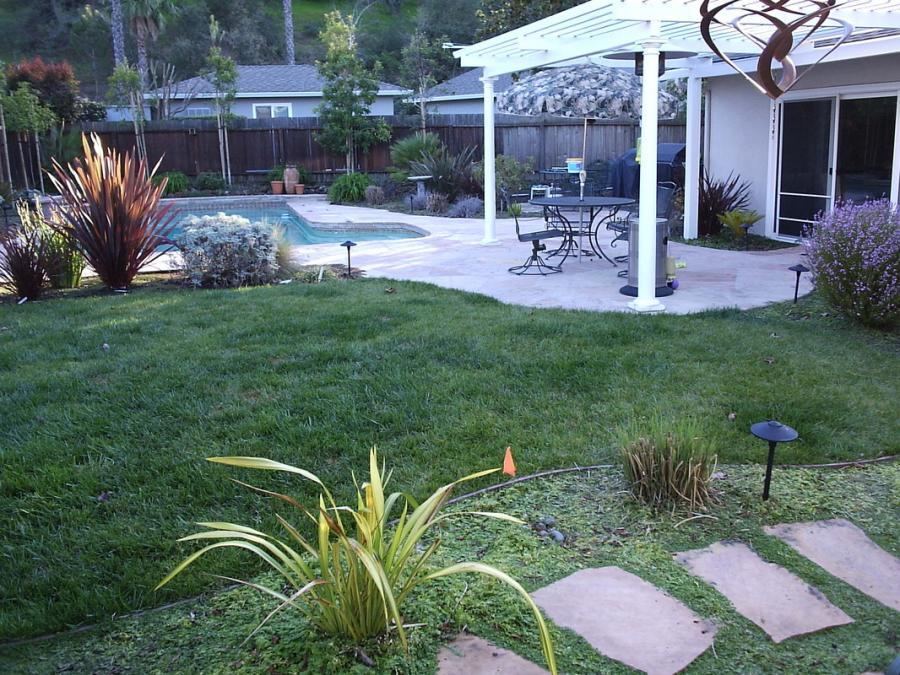 Picture of This outdoor project features a flagstone deck an arbor and a small lawn with flagstone stepping stones. - Natural Landscaping Contractors