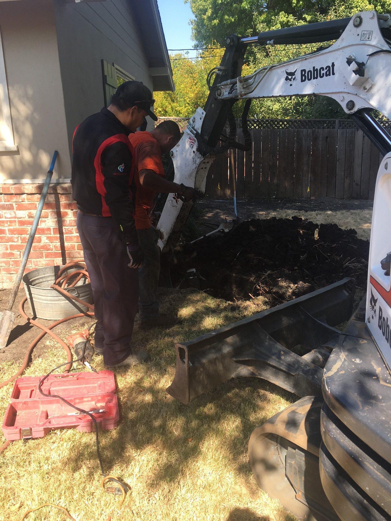 Picture of Two Absolute Plumbing and Drain technicians work on a trenchless sewer replacement project. - Absolute Plumbing and Drain