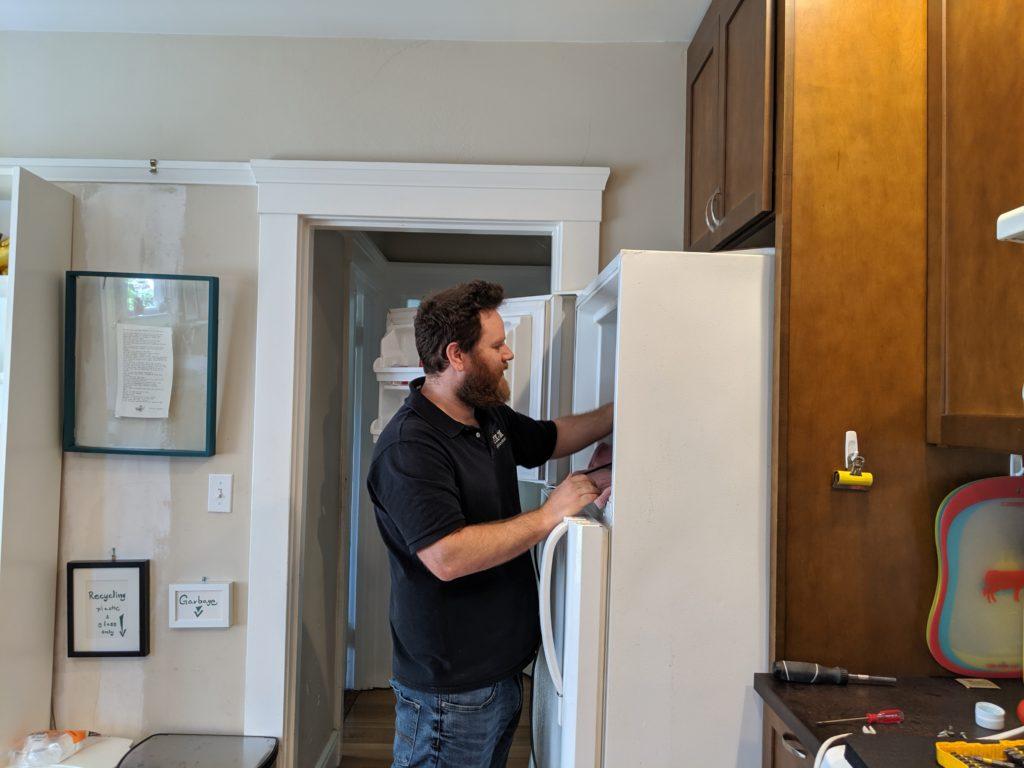 Picture of Co-owner Natan Framowitz diagnoses a customer's refrigerator. - FixEm Appliance Repair