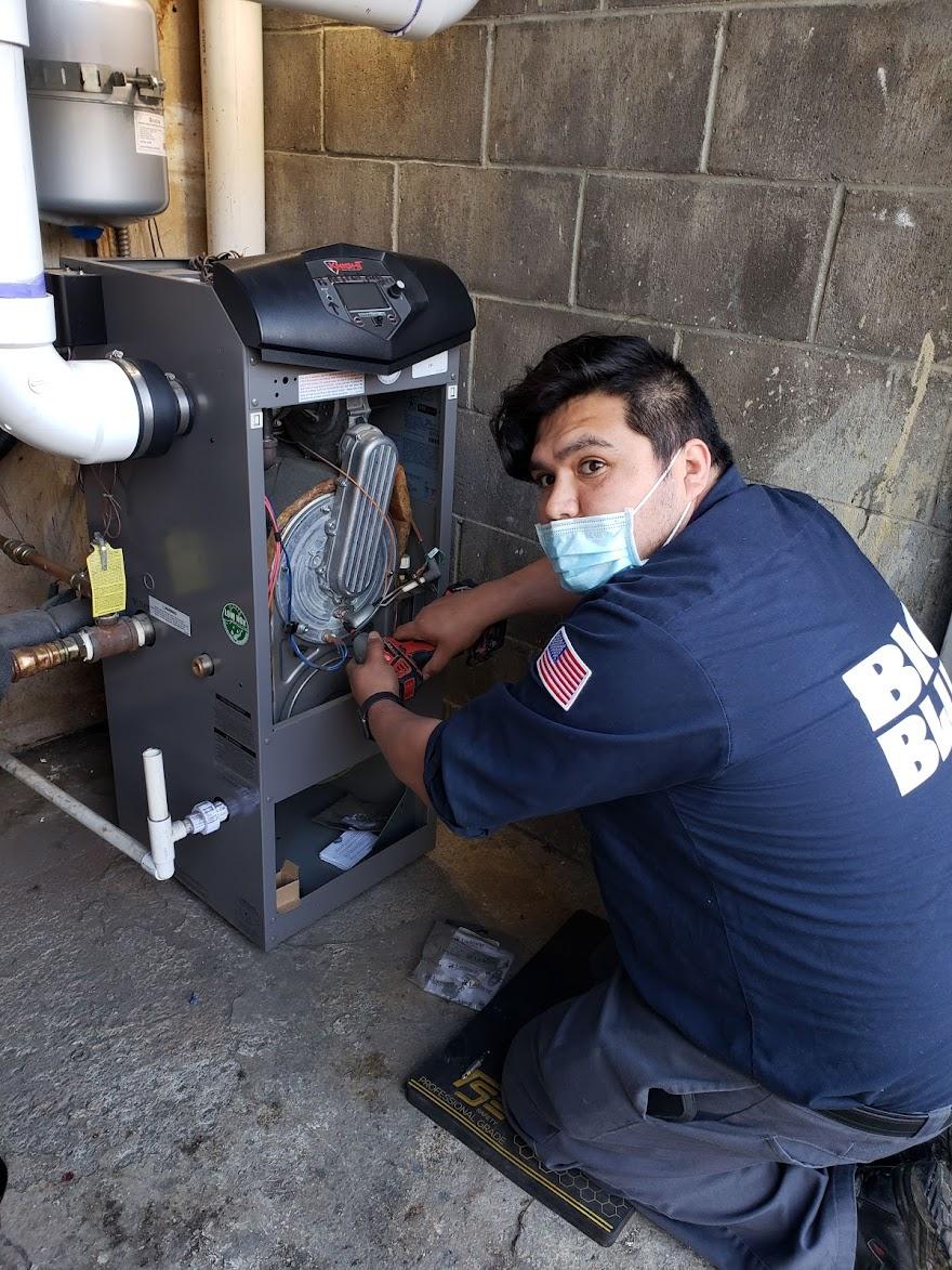Picture of A Big Blue Plumbing technician services a client's boiler. - Big Blue Plumbing