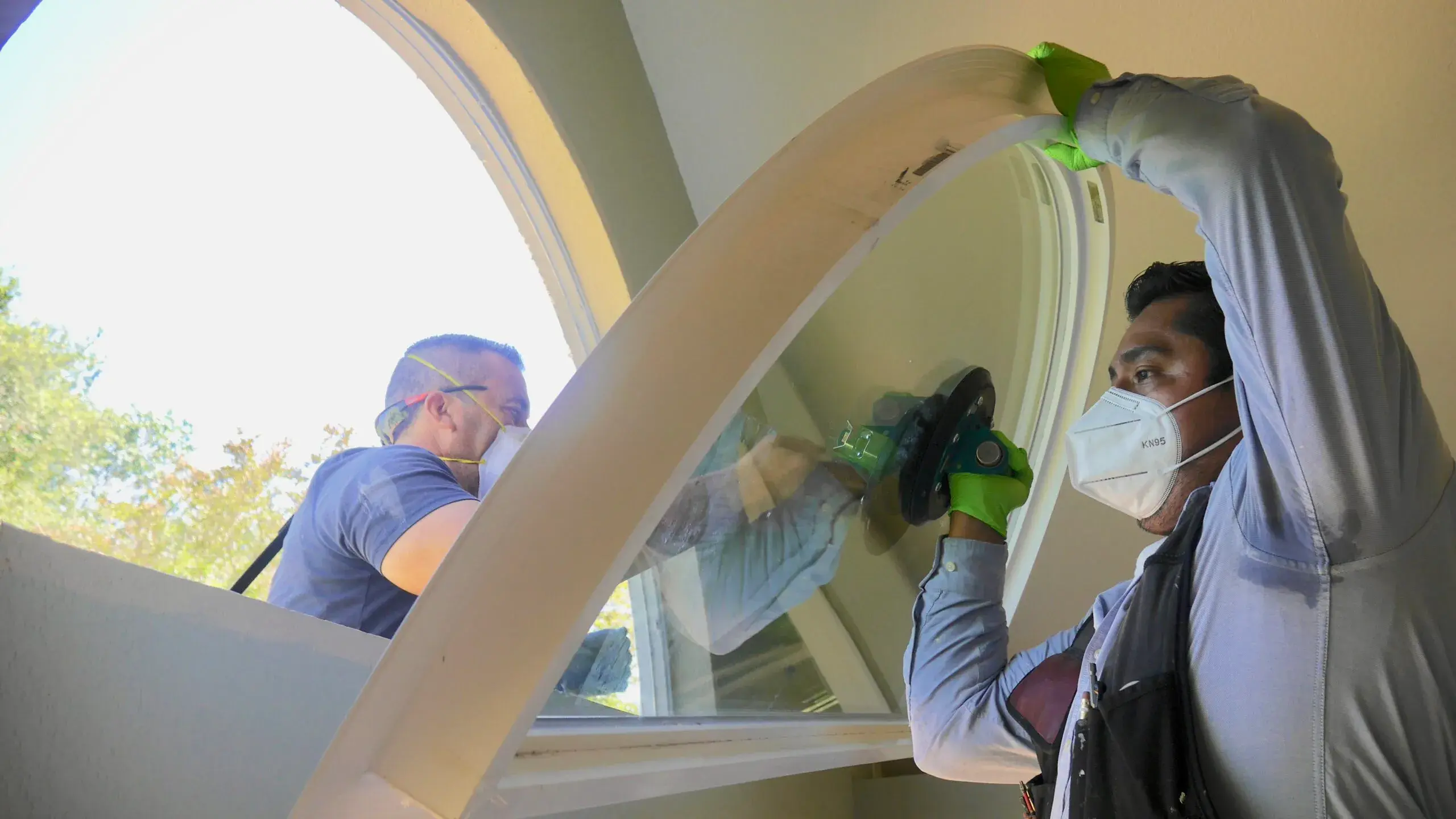 Picture of Master Installers Eduardo and Aldrin carefully install an eyebrow retrofit replacement window. - Save Energy Company