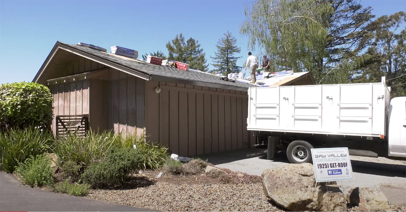 Picture of Under a clear sky, Bay Valley Roofing workers expertly cover a residential roof with new shingles, underscoring the company's focus on quality outcomes. Copyright ©2025 Diamond Certified Resource - Bay Valley Roofing