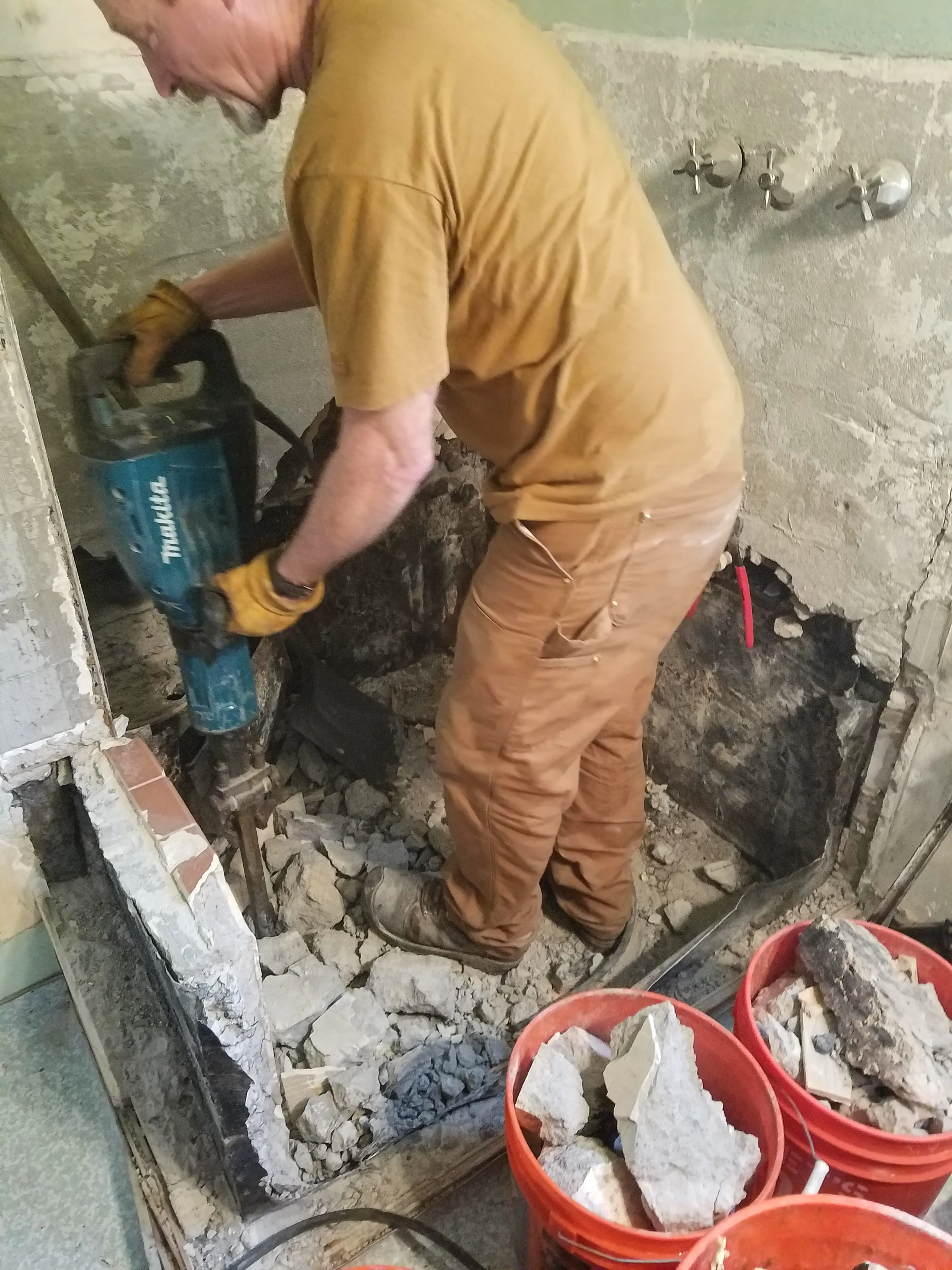 Picture of A worker from Dahme Construction skillfully handles a jackhammer, breaking through layers of old concrete, revealing years of history in the renovation process. Known for their high customer satisfaction ratings, Dahme Construction transforms spaces with precision and care. Copyright ©2025 Diamond Certified Resource

 - Dahme Construction