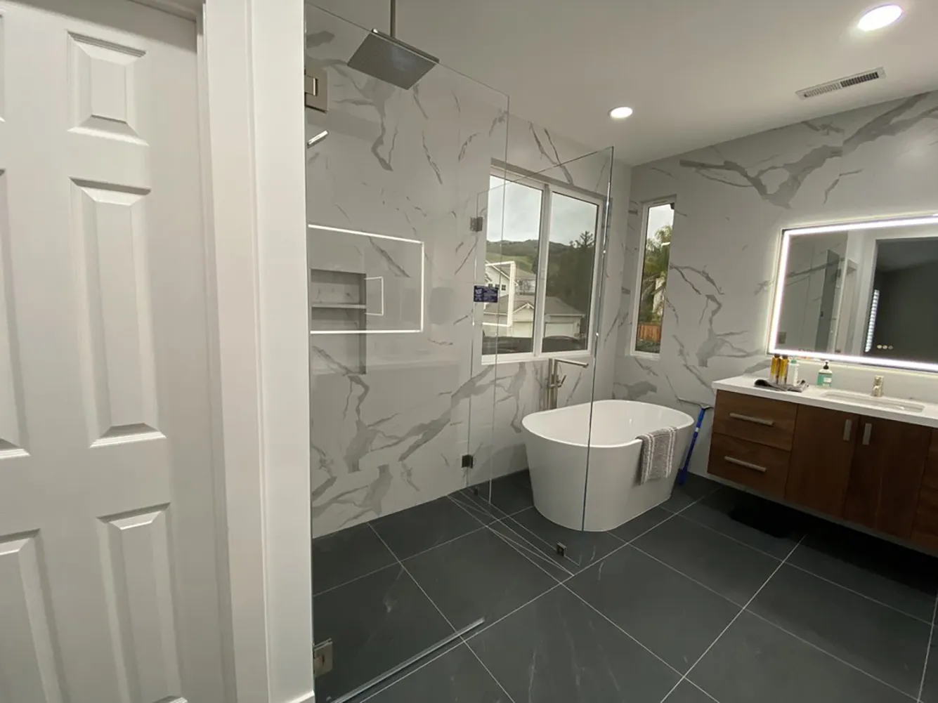 Picture of Amidst the sleek, modern design of a freshly renovated bathroom, a freestanding tub invites relaxation, harmonizing with the elegant marble tiles. Design Miter Tileâ€™s focus on quality outcomes shines through, reflecting their Diamond Certified expertise. Copyright ©2025 Diamond Certified Resource

 - Design Miter Tile