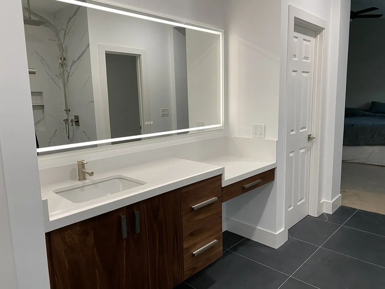 Picture of A sleek, modern bathroom featuring a backlit mirror and a smooth, wood-accented vanity reflects Design Miter Tile's commitment to quality outcomes. With a flawless finish, the space exemplifies why the company consistently achieves a Highest in Quality rating. Copyright ©2025 Diamond Certified Resource

 - Design Miter Tile