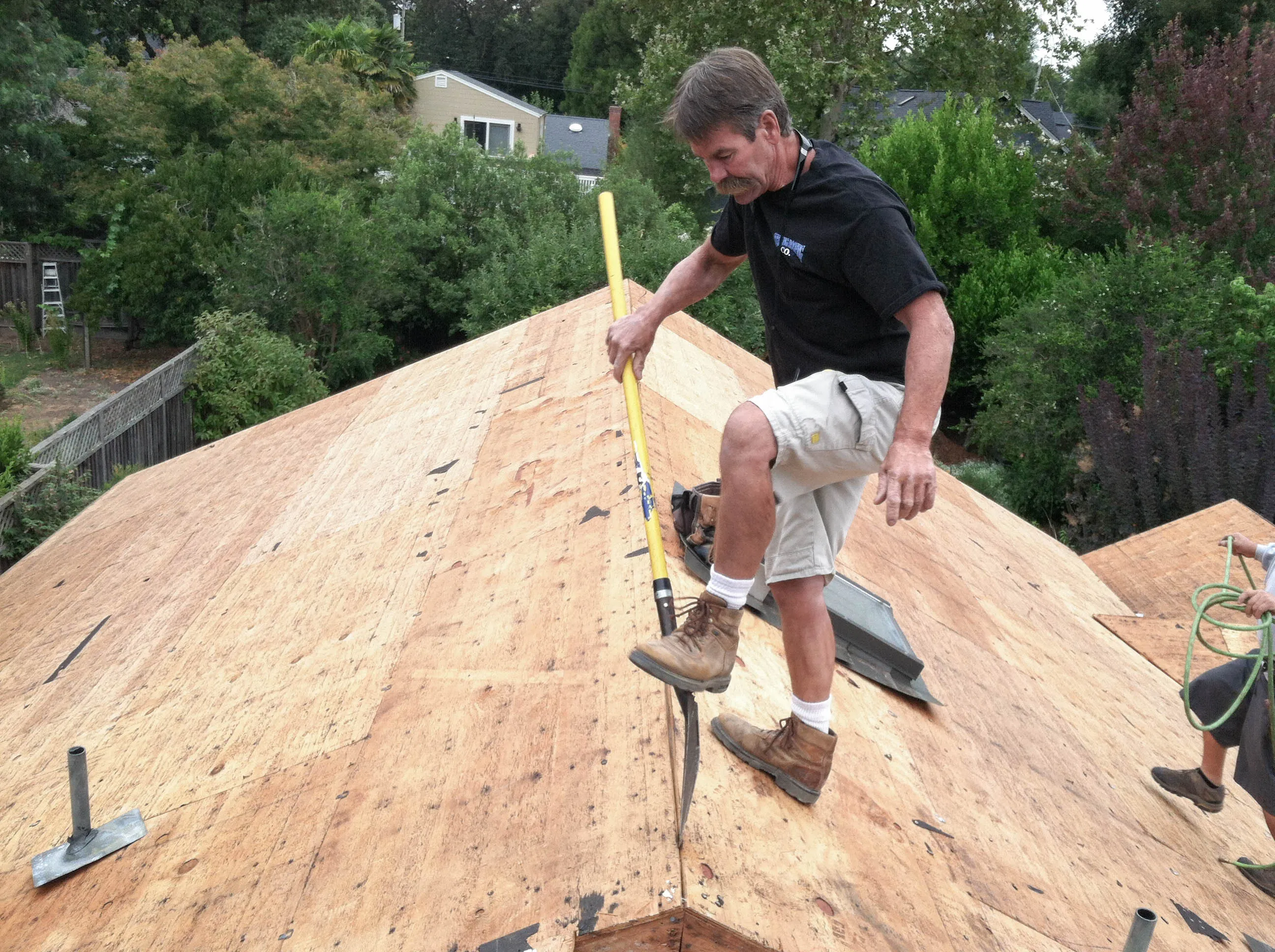 Picture of A skilled worker carefully pries up old roofing material, revealing Sterling Roofing Co., Inc.'s commitment to quality outcomes. This scene exemplifies the company's focus on precision and excellence in every project. Copyright ©2025 Diamond Certified Resource

 - Sterling Roofing Co., Inc.