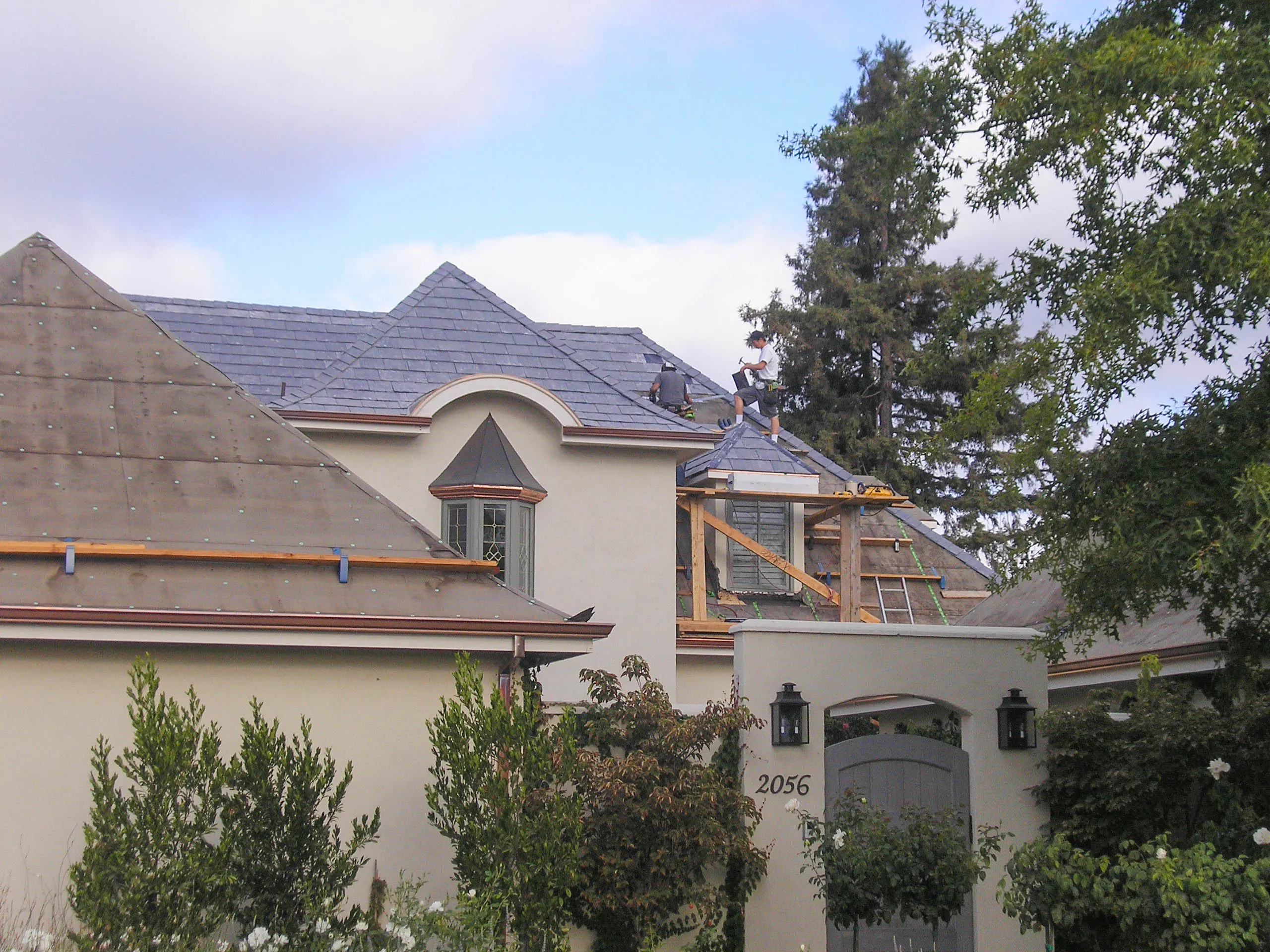 Picture of Two roofing specialists align shingles with precision on a multi-gabled home, exemplifying Sterling Roofing Co., Inc.'s focus on quality outcomes. Their expertise ensures a flawless finish. Copyright ©2025 Diamond Certified Resource

 - Sterling Roofing Co., Inc.