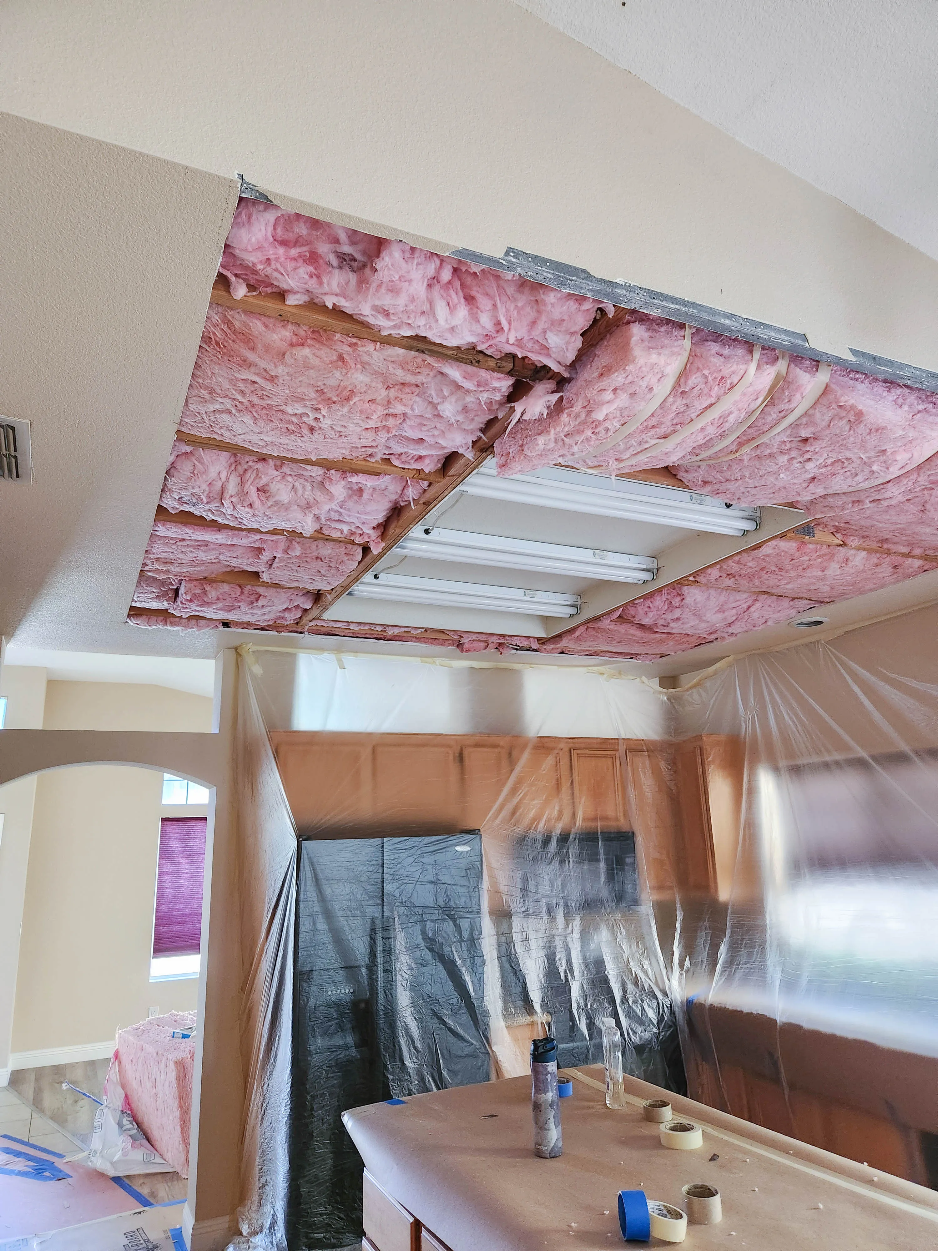 Picture of Beneath the open ceiling, pink insulation is carefully set into place, illustrating Sulvaran Drywallâ€™s commitment to quality outcomes. This meticulous process underscores their dedication to maintaining high customer satisfaction. Copyright ©2025 Diamond Certified Resource - Sulvaran Drywall