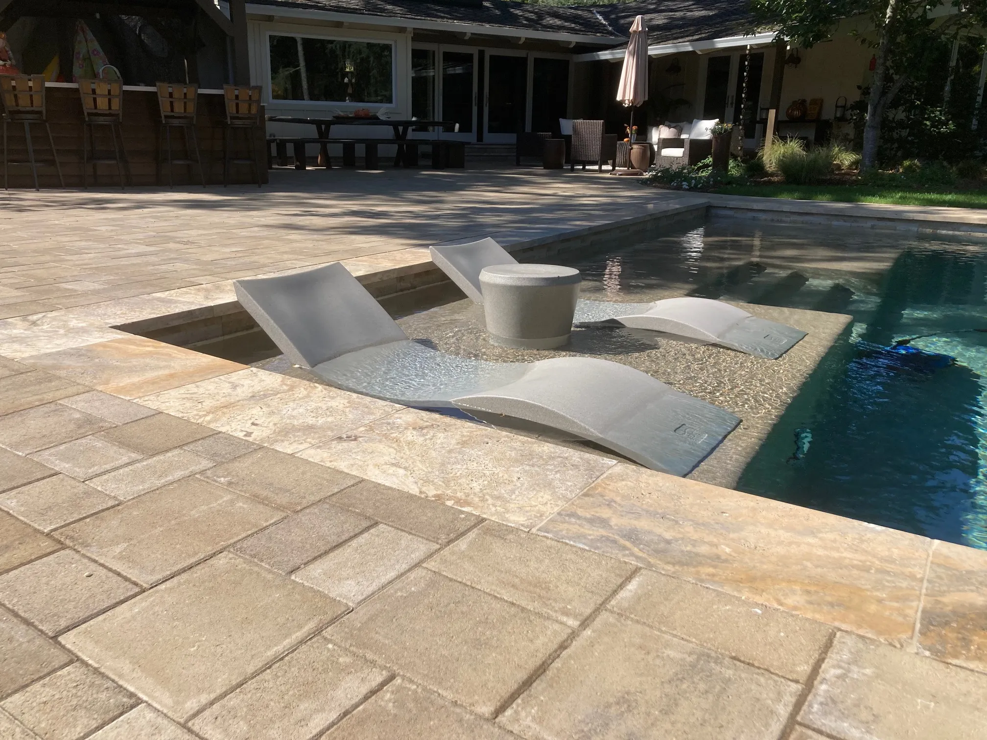 Picture of Sunlight dances across the elegantly designed poolside lounge area, crafted by The Legacy Paver Group. Their focus on quality outcomes transforms outdoor spaces into serene retreats. Copyright ©2025 Diamond Certified Resource

 - The Legacy Paver Group