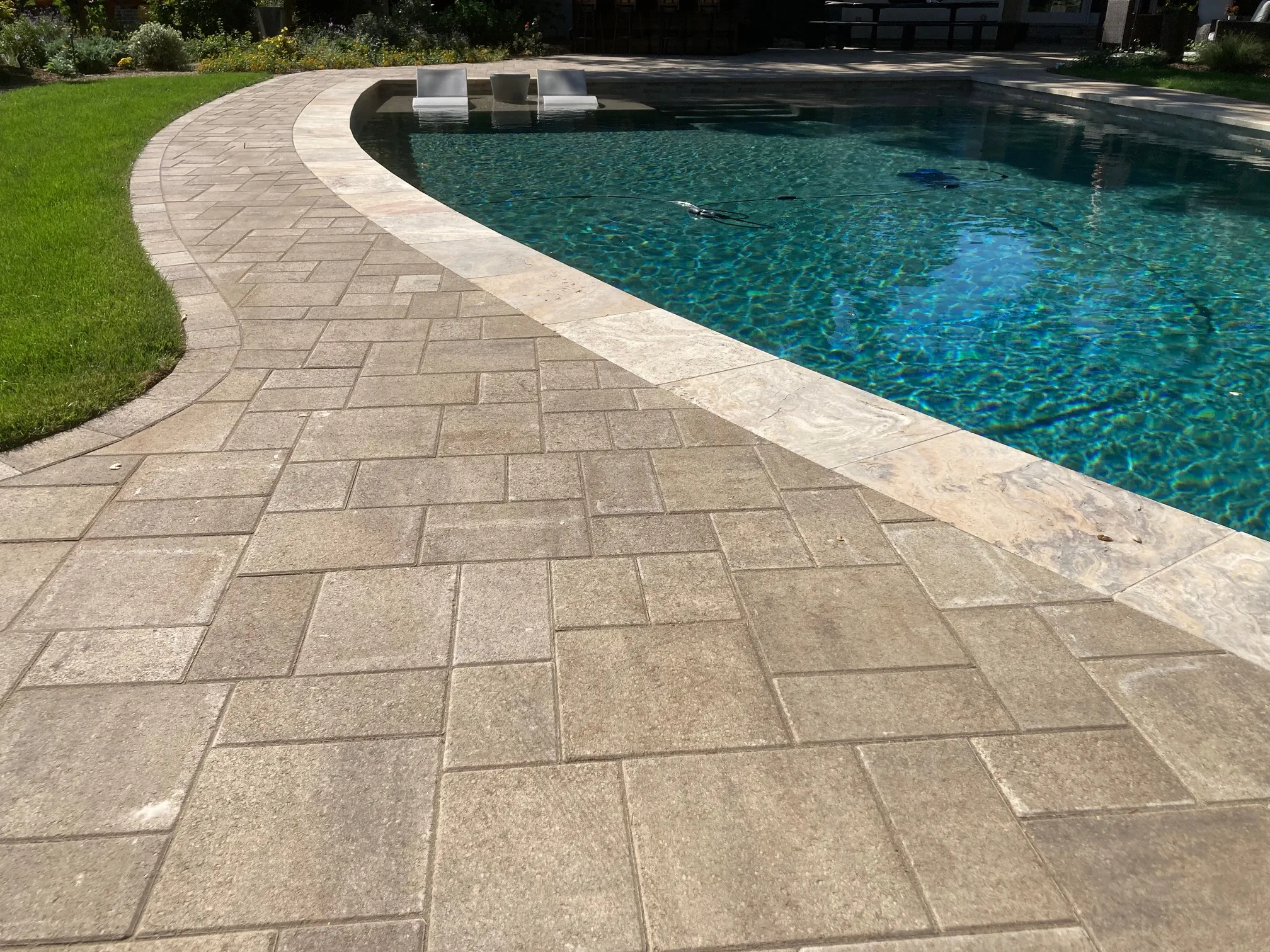 Picture of Sunlight dances across a meticulously paved poolside, echoing The Legacy Paver Group's commitment to quality outcomes and high customer satisfaction. This serene scene highlights the company's expertise in creating inviting outdoor spaces. Copyright ©2025 Diamond Certified Resource

 - The Legacy Paver Group