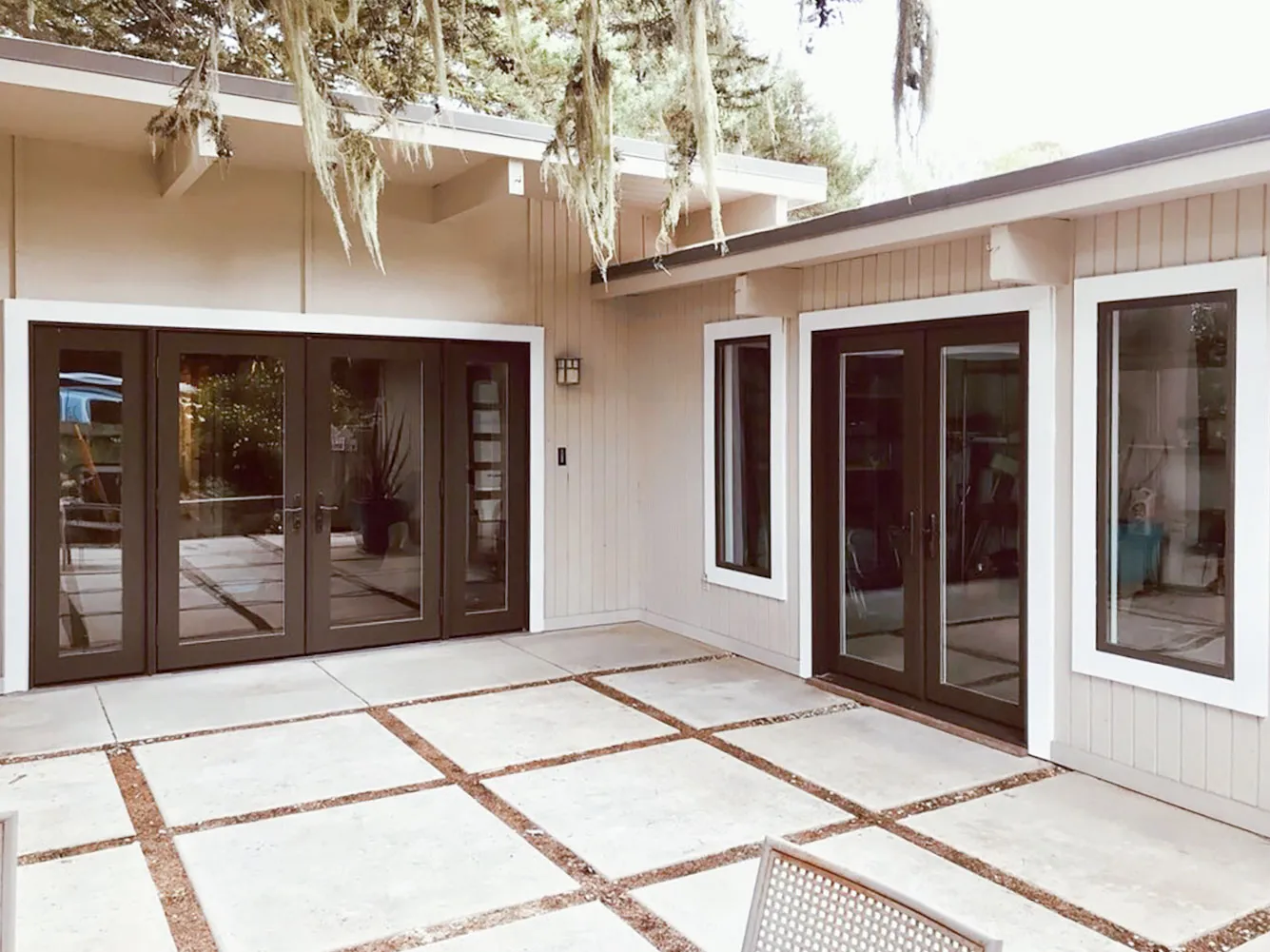 Picture of The serene courtyard of a modern home features sleek, dark-framed windows and doors by Abstract Windows, seamlessly merging indoor and outdoor spaces. Recognized for expertise and quality, the company exemplifies a focus on quality outcomes. Copyright ©2025 Diamond Certified Resource - Abstract Windows