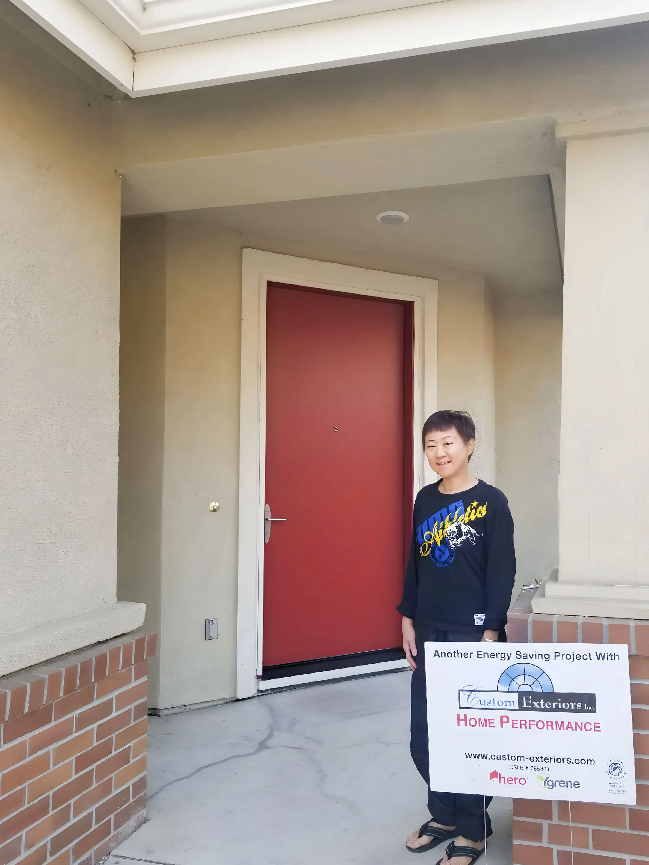 Picture of A proud homeowner stands beside her freshly updated entrance, showcasing the seamless integration of style and energy efficiency by Custom Exteriors, Inc., a company recognized for expertise and quality. Copyright ©2025 Diamond Certified Resource - Custom Exteriors, Inc.