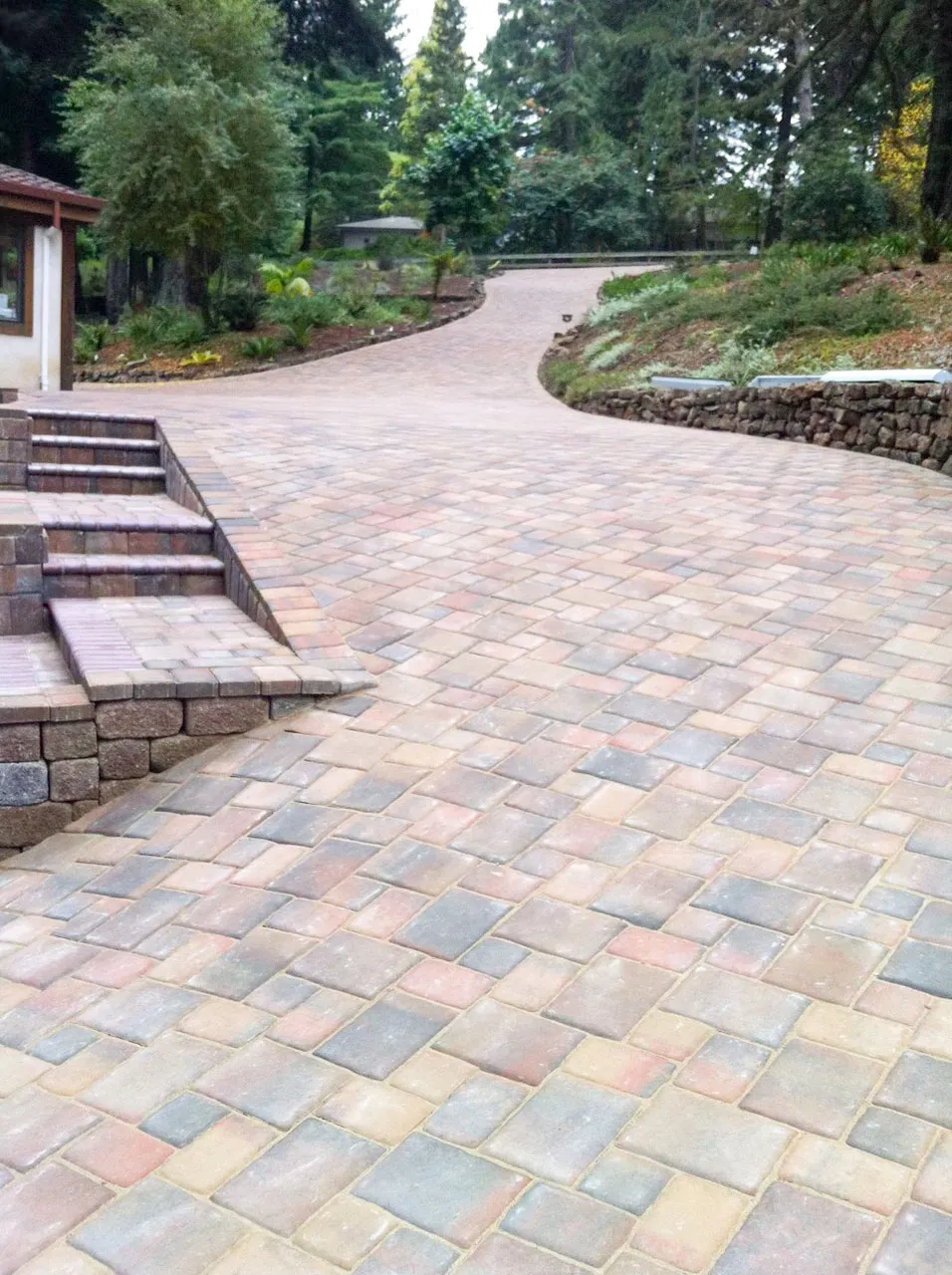 Picture of A meticulously crafted stone driveway gracefully curves through a lush landscape, showcasing Mr. Pavers Contractor Services, Inc.'s dedication to quality outcomes. The intricate pattern reflects their recognition for expertise and quality. Copyright ©2025 Diamond Certified Resource - Mr. Pavers Contractor Services, Inc.