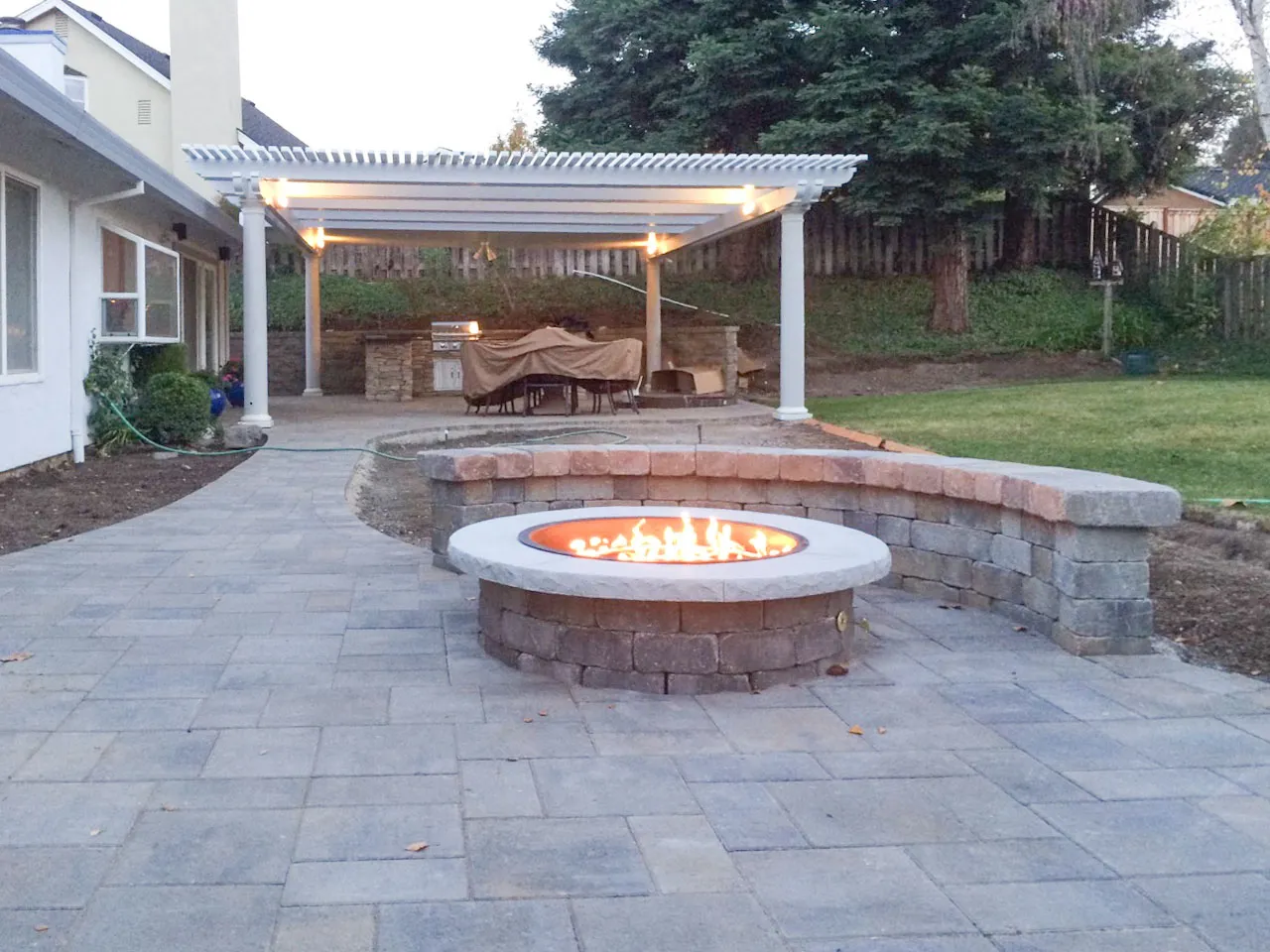 Picture of A serene backyard retreat featuring a stone fire pit complements a covered patio with an outdoor grill. This inviting space, crafted by Mr. Pavers Contractor Services, Inc., reflects their focus on quality outcomes. Copyright ©2025 Diamond Certified Resource

 - Mr. Pavers Contractor Services, Inc.