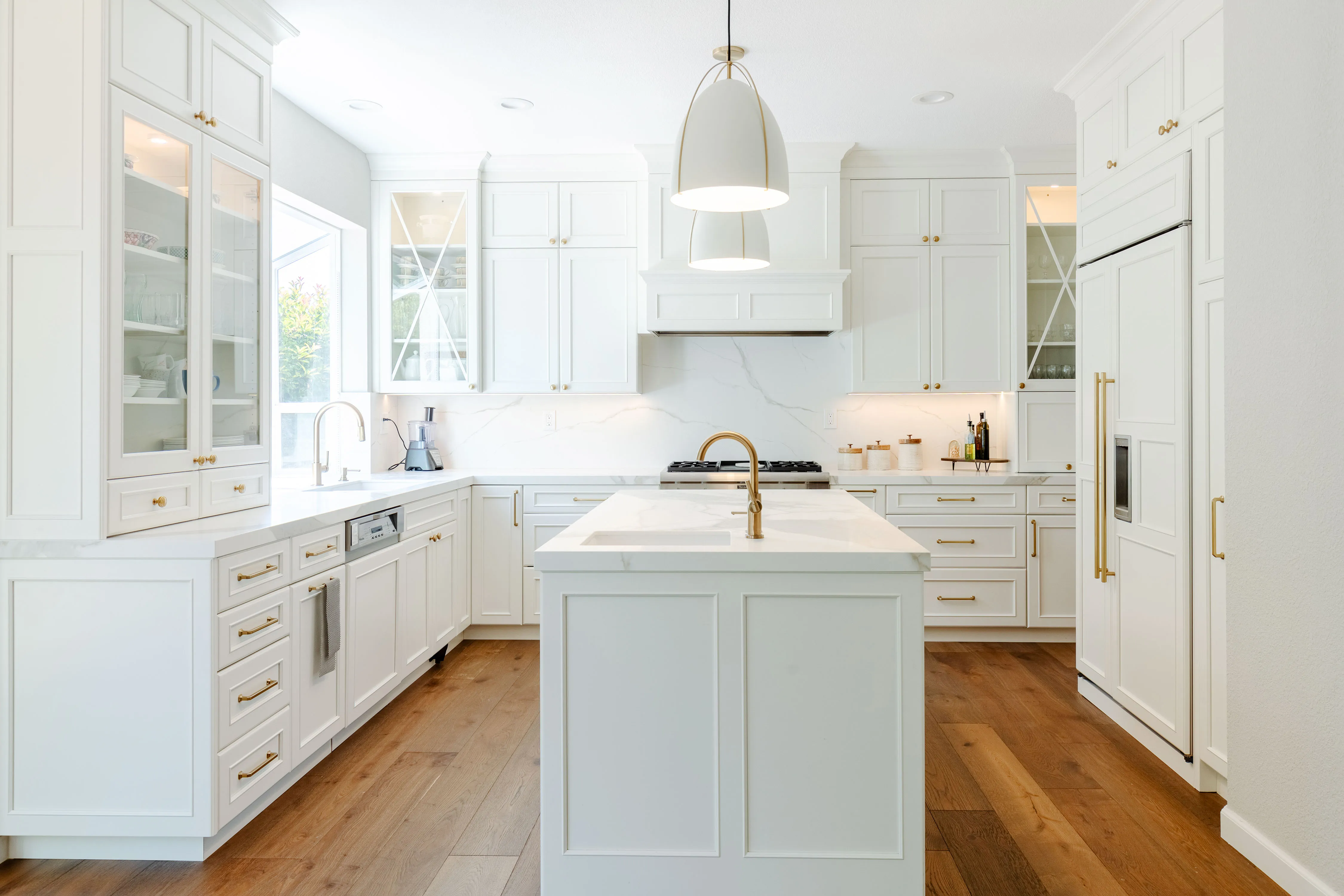 Picture of Sunlight streams into a pristine kitchen, highlighting the elegant brass fixtures and seamless white cabinetryâ€”an embodiment of NuHome Remodeling's dedication to quality outcomes. Copyright ©2025 Diamond Certified Resource

 - NuHome Remodeling