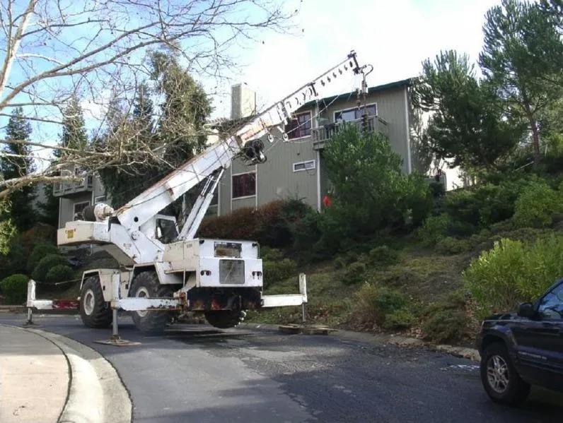 Picture of  A heavy-duty crane stabilizes on a suburban street, its arm extended towards a hillside home, showcasing Engineered Soil Repairs, Inc.'s commitment to quality outcomes. The company's dedication to achieving the highest customer satisfaction is evident in every project. Copyright ©2025 Diamond Certified Resource.

 - Engineered Soil Repairs, Inc.